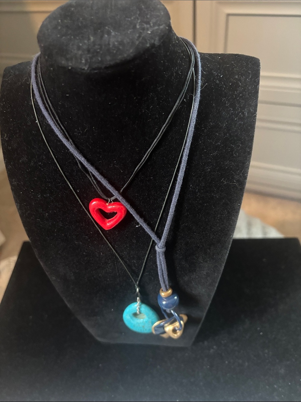 3 cloth string necklaces with pendants.